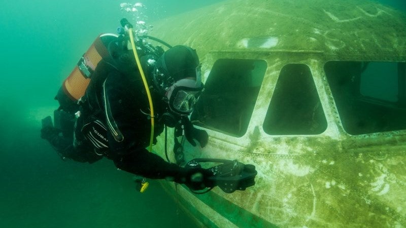 diver inspects plane wreckage